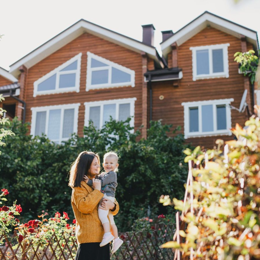 young-mother-and-her-baby-standing-near-house-in-a-2024-12-02-22-42-35-utc